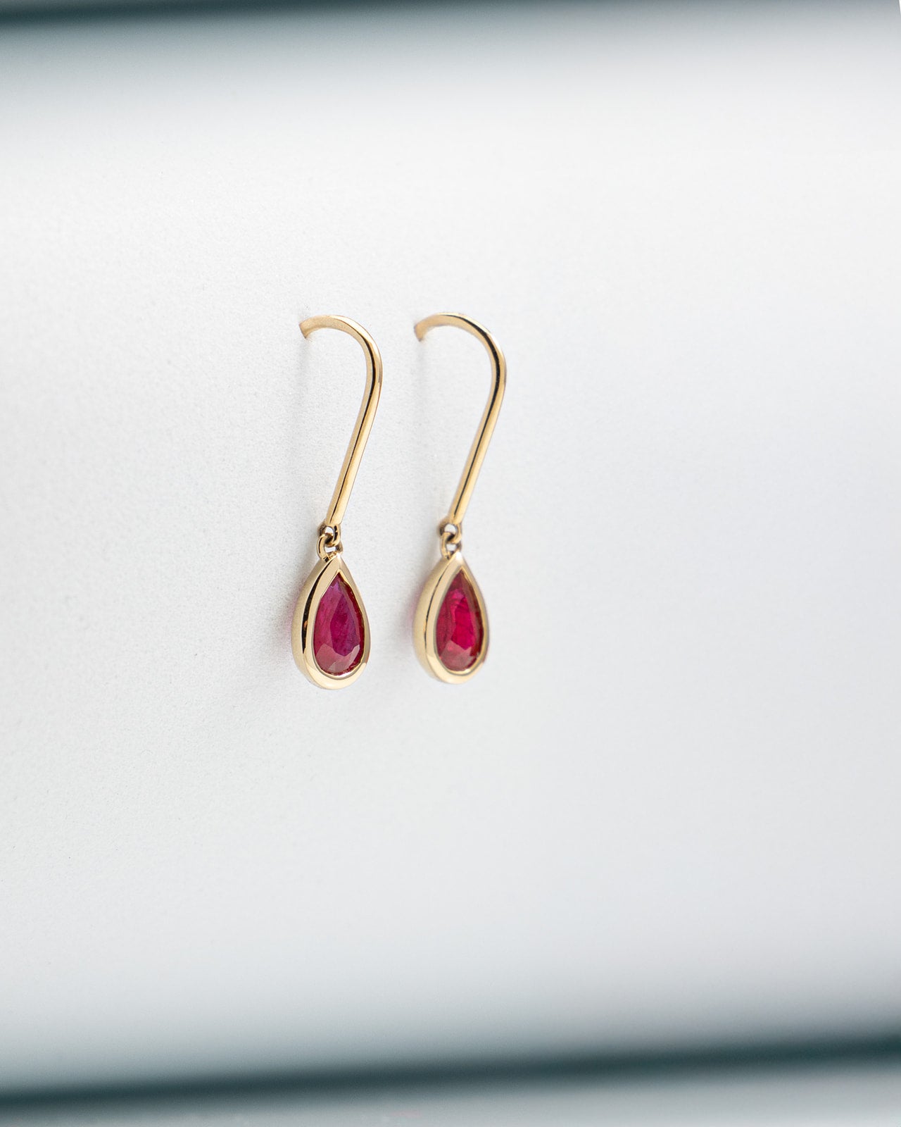 Pear Ruby Bezel Set Dangle Earrings in Yellow Gold