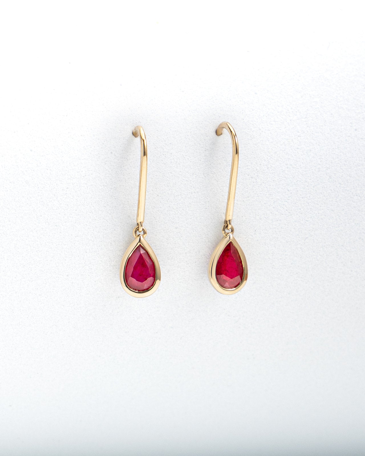 Pear Ruby Bezel Set Dangle Earrings in Yellow Gold