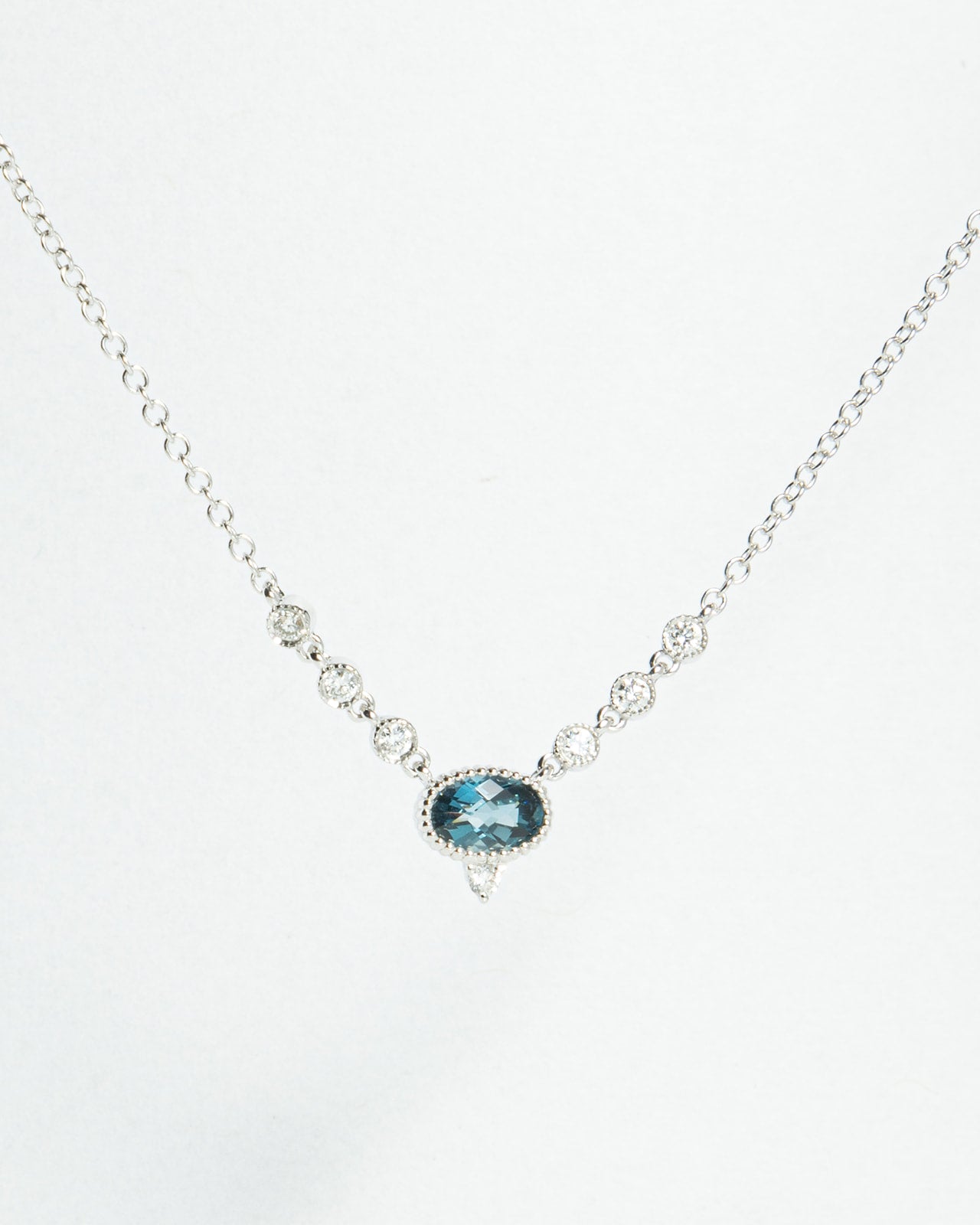 Oval Blue Topaz and Diamond V Pendant in White Gold